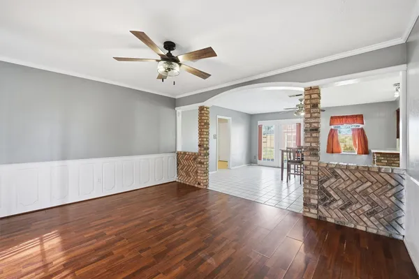 a view of an empty room with window and wooden floor