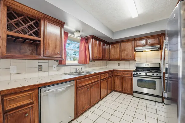a kitchen with stainless steel appliances granite countertop a sink stove and cabinets