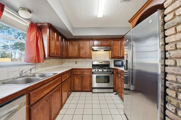 a kitchen with stainless steel appliances granite countertop a refrigerator and a sink