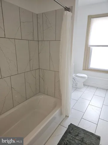a bathroom with a bathtub and window