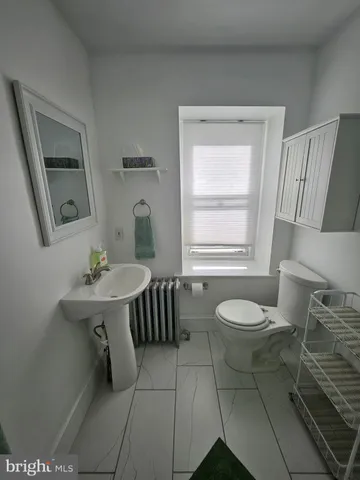 a bathroom with a sink toilet a mirror and window