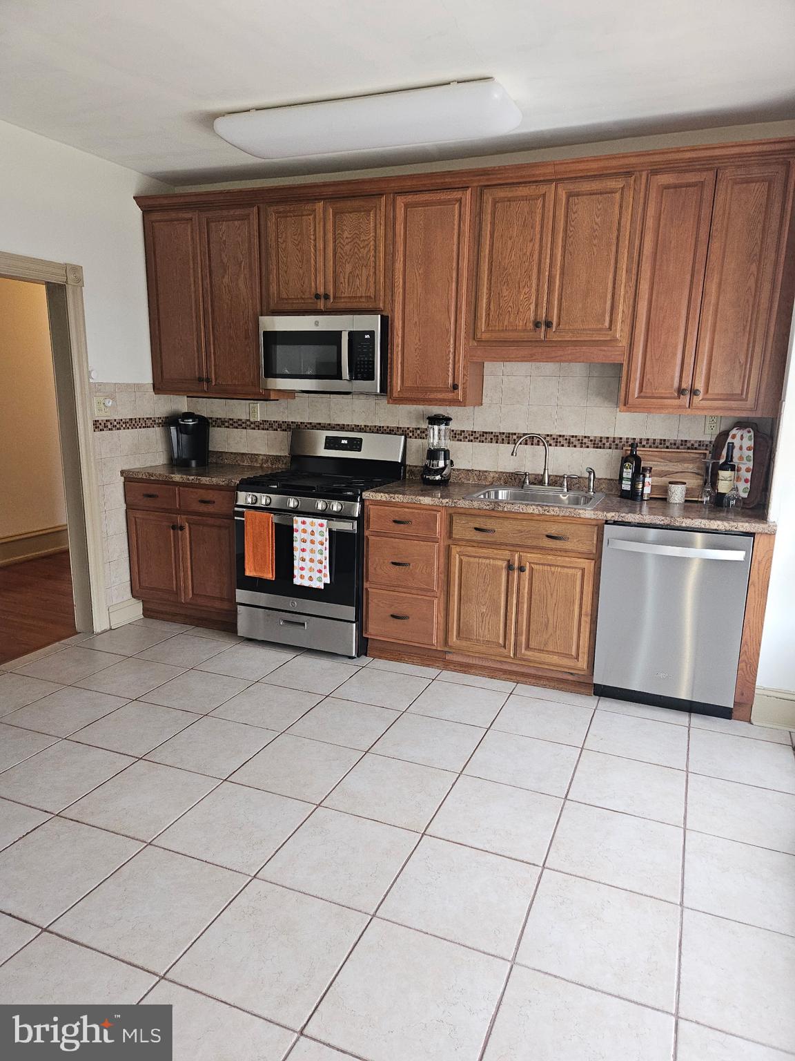 4356 Manayunk Avenue, Unit 2 Philadelphia, PA 19128 - Photo 43 of 43 a kitchen with stainless steel appliances granite countertop a stove top oven a sink a microwave and a refrigerator