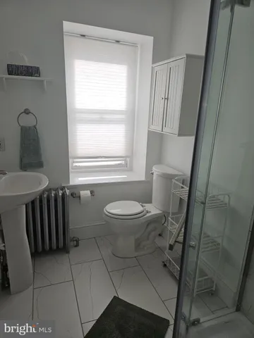 a bathroom with a toilet a sink and a window