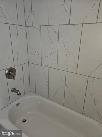 a bathroom with a white bath tub and a sink