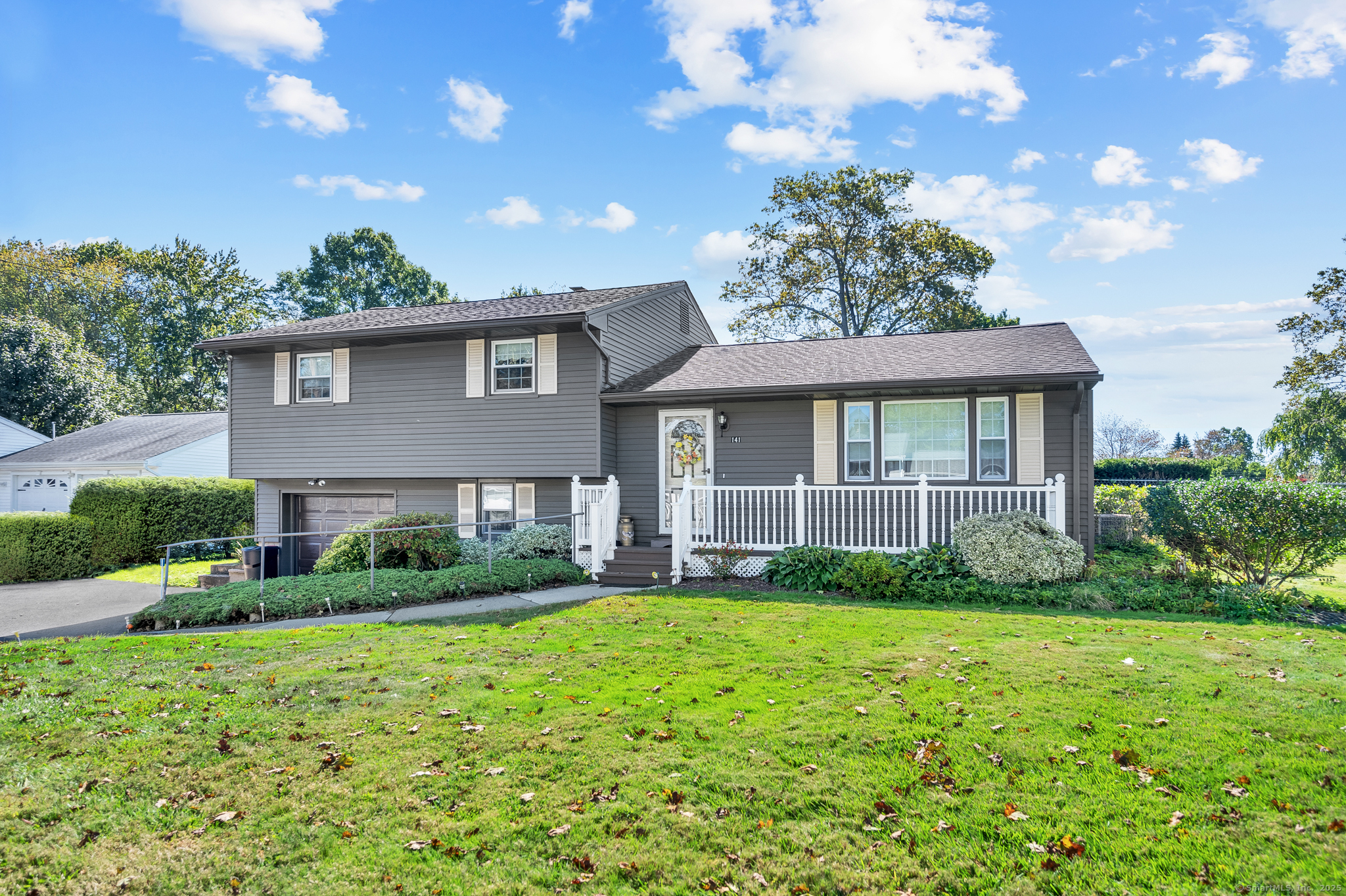a view of a house next to a yard with plants and trees