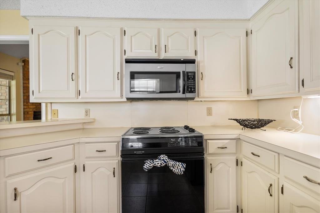 2824 Crestview Avenue Tyler, TX 75701 - Photo 13 of 39 a kitchen with granite countertop white cabinets and black appliances