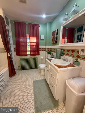 a bathroom with a sink a toilet and mirror