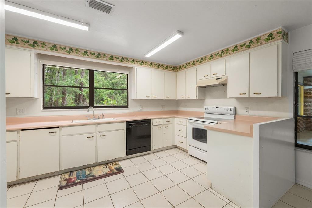 4703 Northwest 124th Street Gainesville, FL 32606 - Photo 22 of 55 a kitchen with a stove a sink and a refrigerator