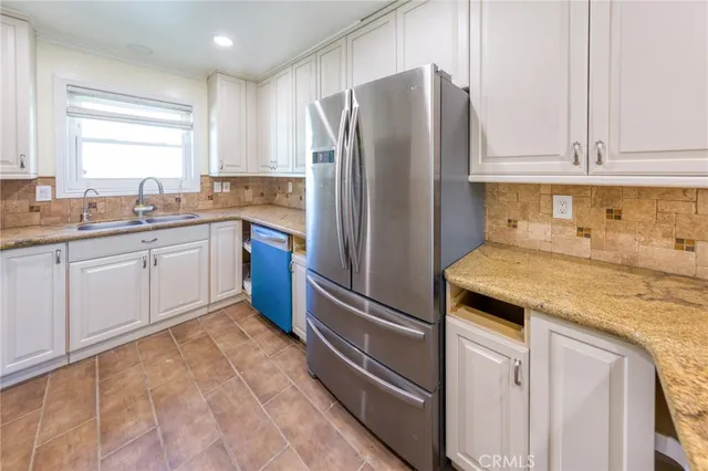 a kitchen with stainless steel appliances granite countertop a refrigerator and a sink