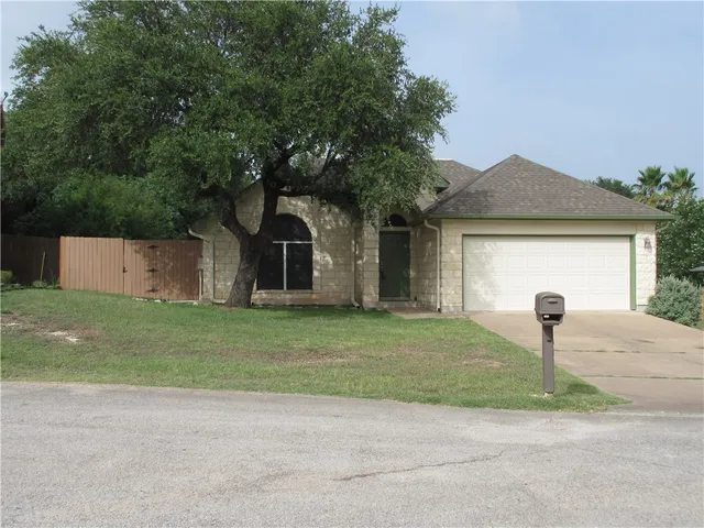 a front view of a house with a garden and yard