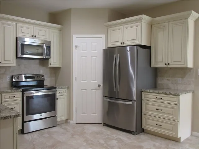 a kitchen with stainless steel appliances white cabinets and a refrigerator