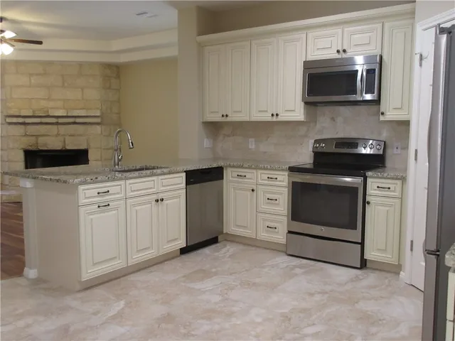 a kitchen with white cabinets and stainless steel appliances