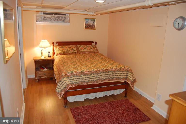 101 Overhill Road Baltimore, MD 21210 - Photo 18 of 24 a bedroom with a bed and wooden floor