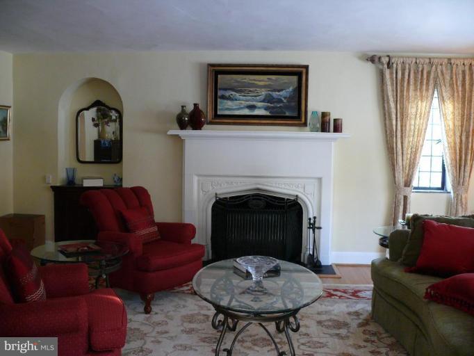 101 Overhill Road Baltimore, MD 21210 - Photo 3 of 24 a living room with furniture two windows and a fireplace