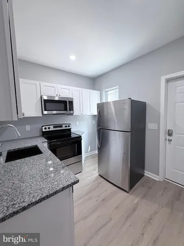 a kitchen with a refrigerator a microwave a sink and cabinets