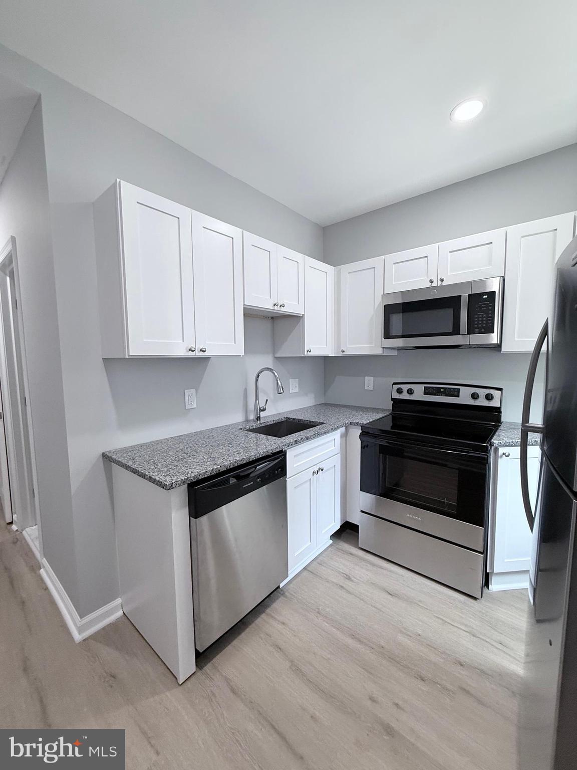 2415 Federal Street Baltimore, MD 21213 - Photo 15 of 35 a kitchen with sink a microwave and cabinets