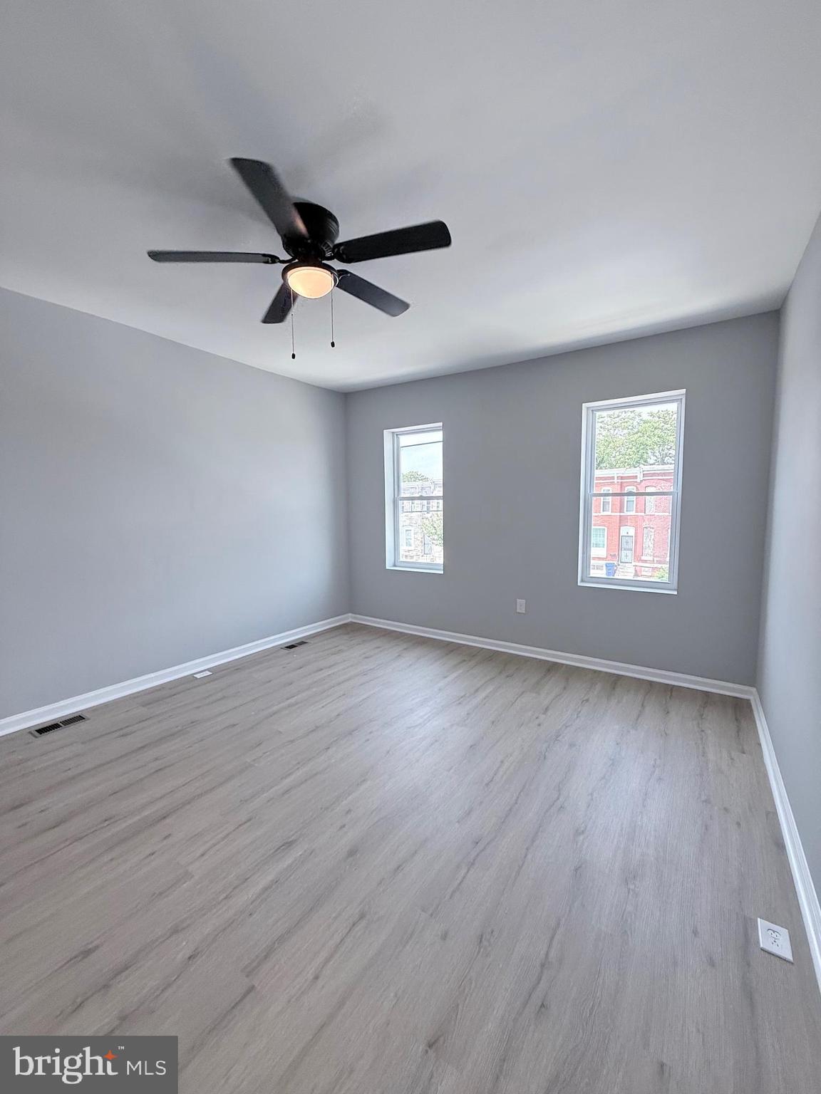 2415 Federal Street Baltimore, MD 21213 - Photo 24 of 35 an empty room with wooden floor ceiling fan and windows