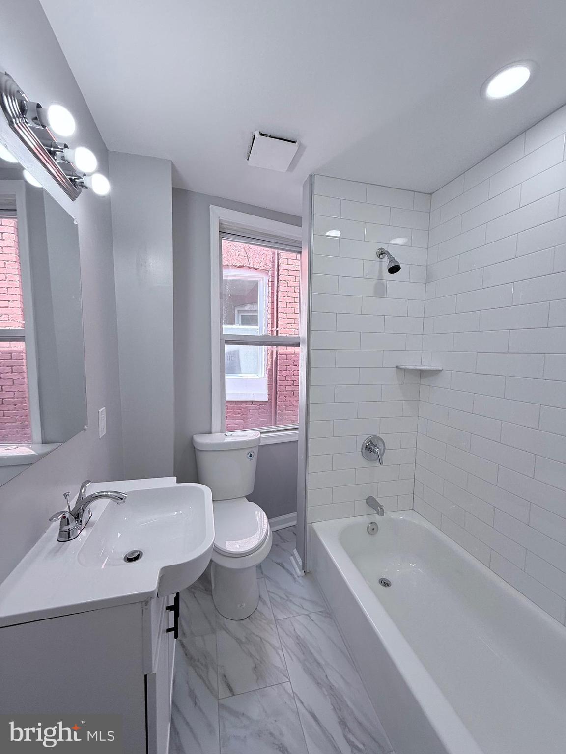 2415 Federal Street Baltimore, MD 21213 - Photo 30 of 35 a bathroom with a sink a toilet a mirror a bathtub and shower