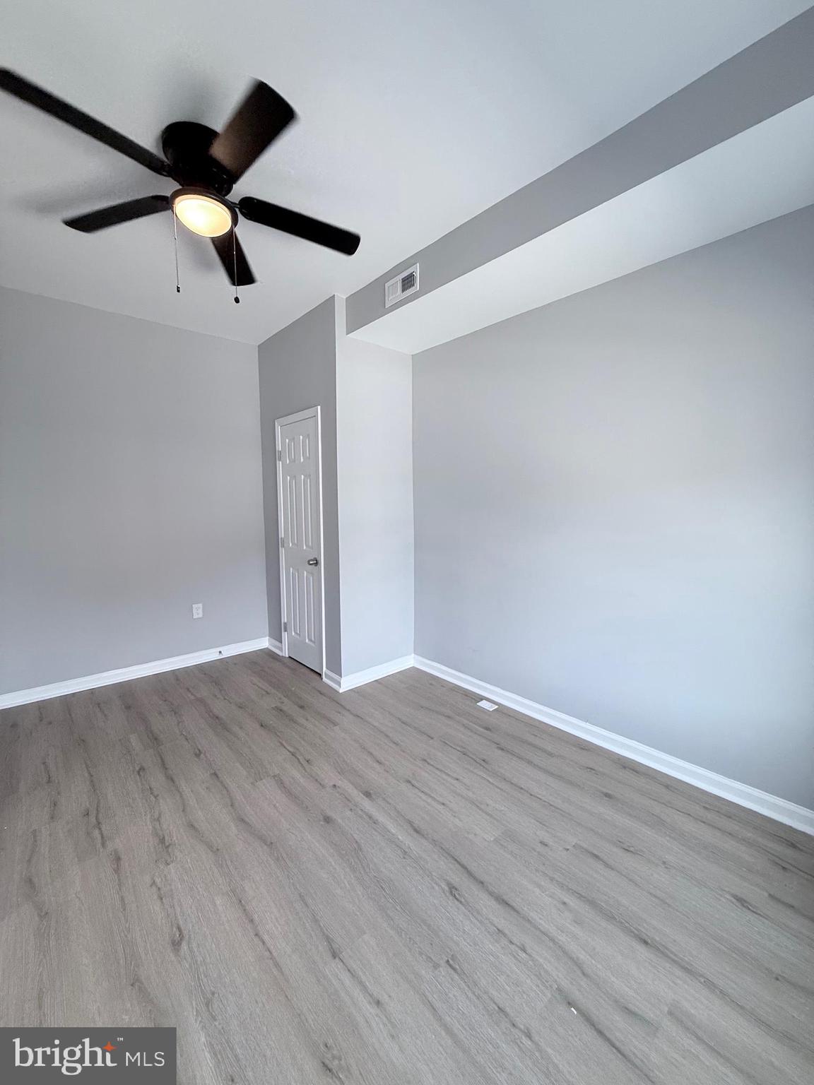 2415 Federal Street Baltimore, MD 21213 - Photo 3 of 35 an empty room with wooden floor ceiling fan and window