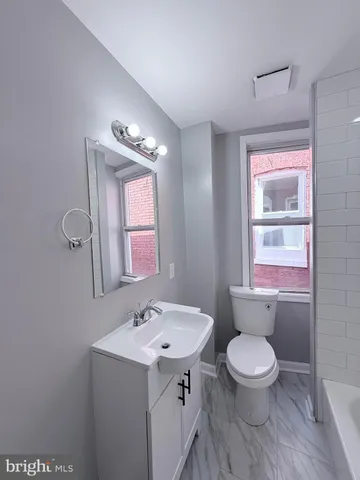 a bathroom with a toilet sink and mirror
