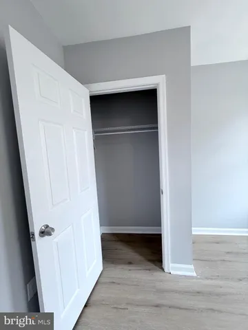 a view of walk in closet with wooden floor