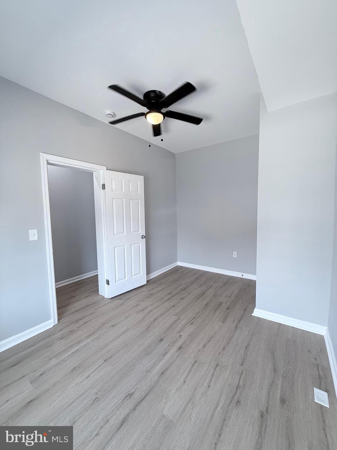 2415 Federal Street Baltimore, MD 21213 - Photo 4 of 35 an empty room with wooden floor ceiling fan and windows