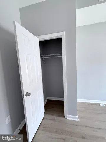 a view of walk in closet with wooden floor