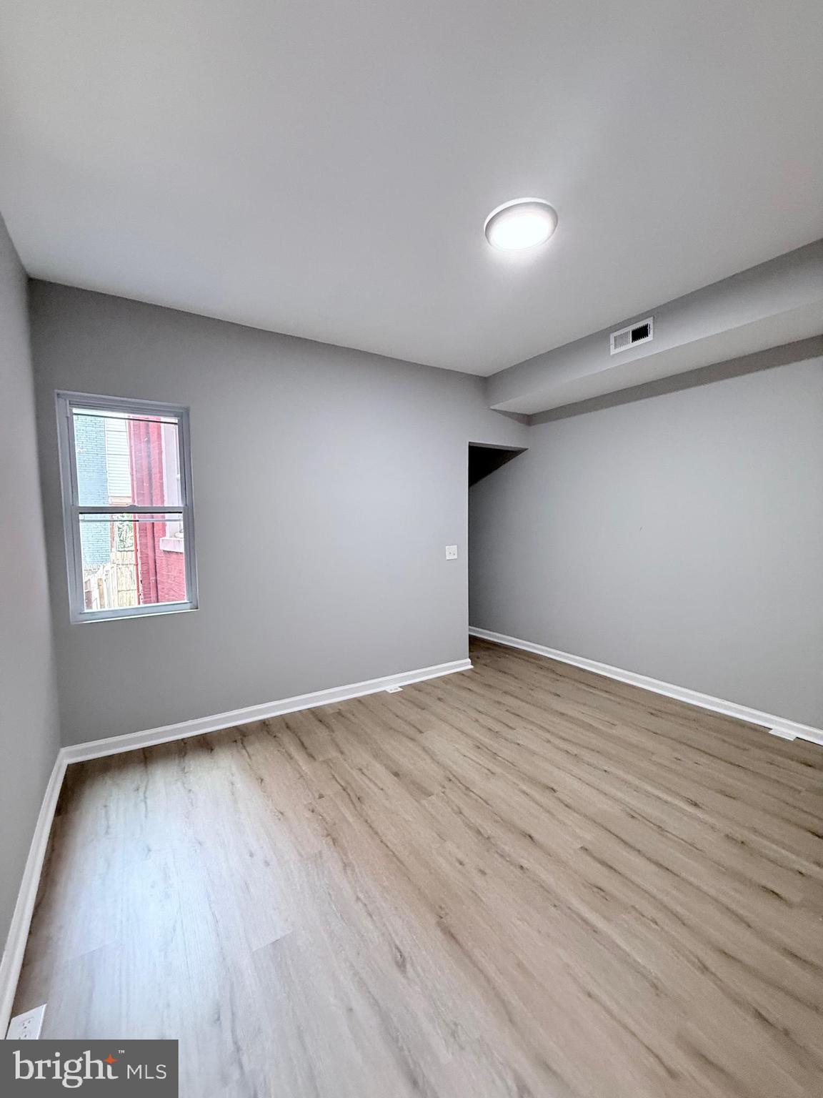 2415 Federal Street Baltimore, MD 21213 - Photo 9 of 35 a view of an empty room with wooden floor and a window