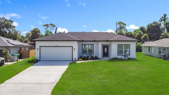 a front view of a house with a garden and yard