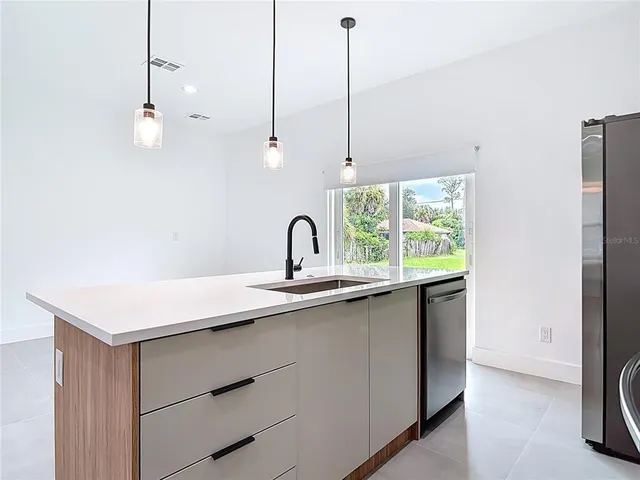 a kitchen with a sink a window and stainless steel appliances