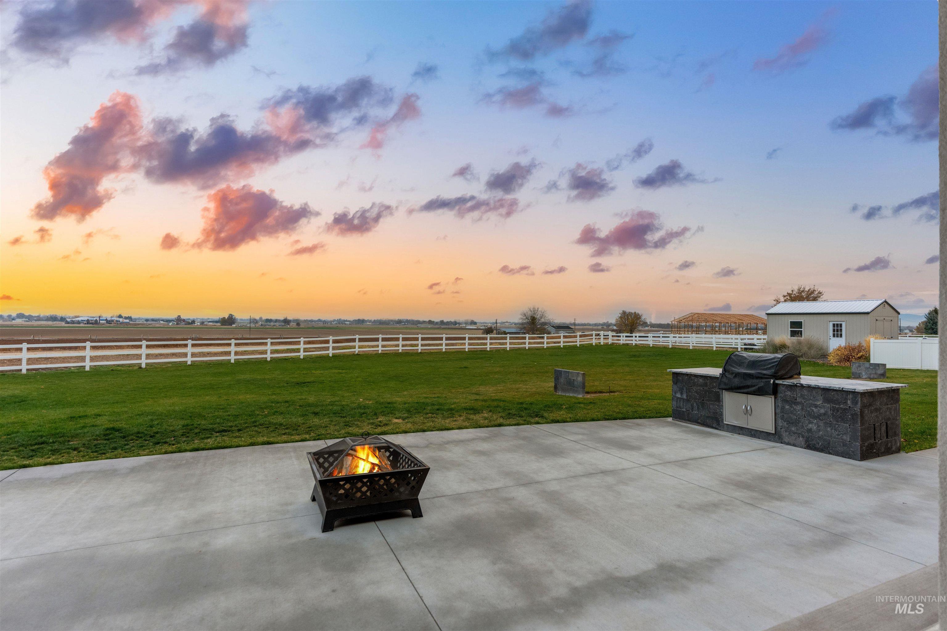 12334 Rivendell Court Nampa, ID 83686 - Photo 48 of 50 Fenced backyard with a patio, an outdoor fire pit, and area for grilling