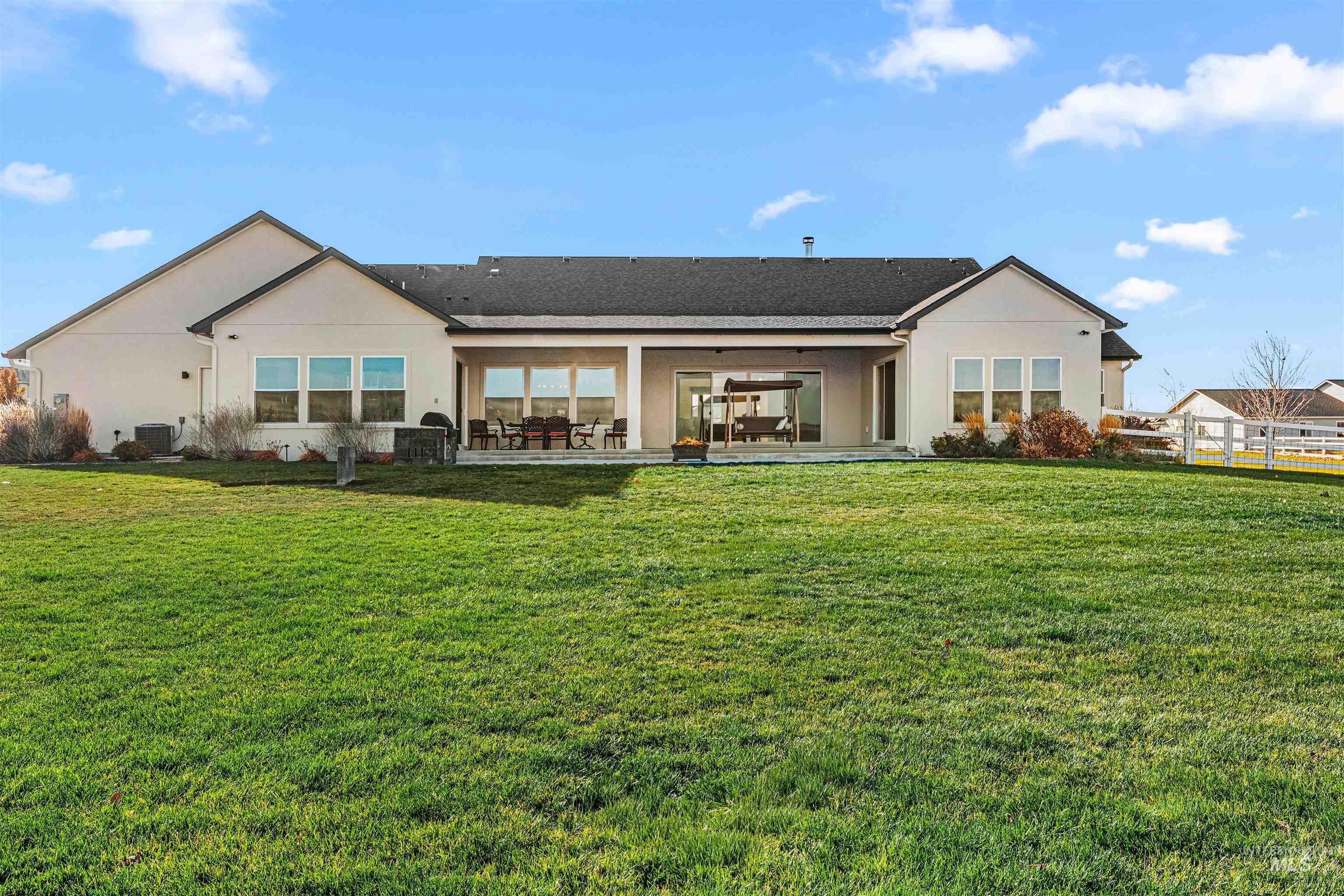 12334 Rivendell Court Nampa, ID 83686 - Photo 49 of 50 Back of property featuring a patio, a lawn, and stucco siding