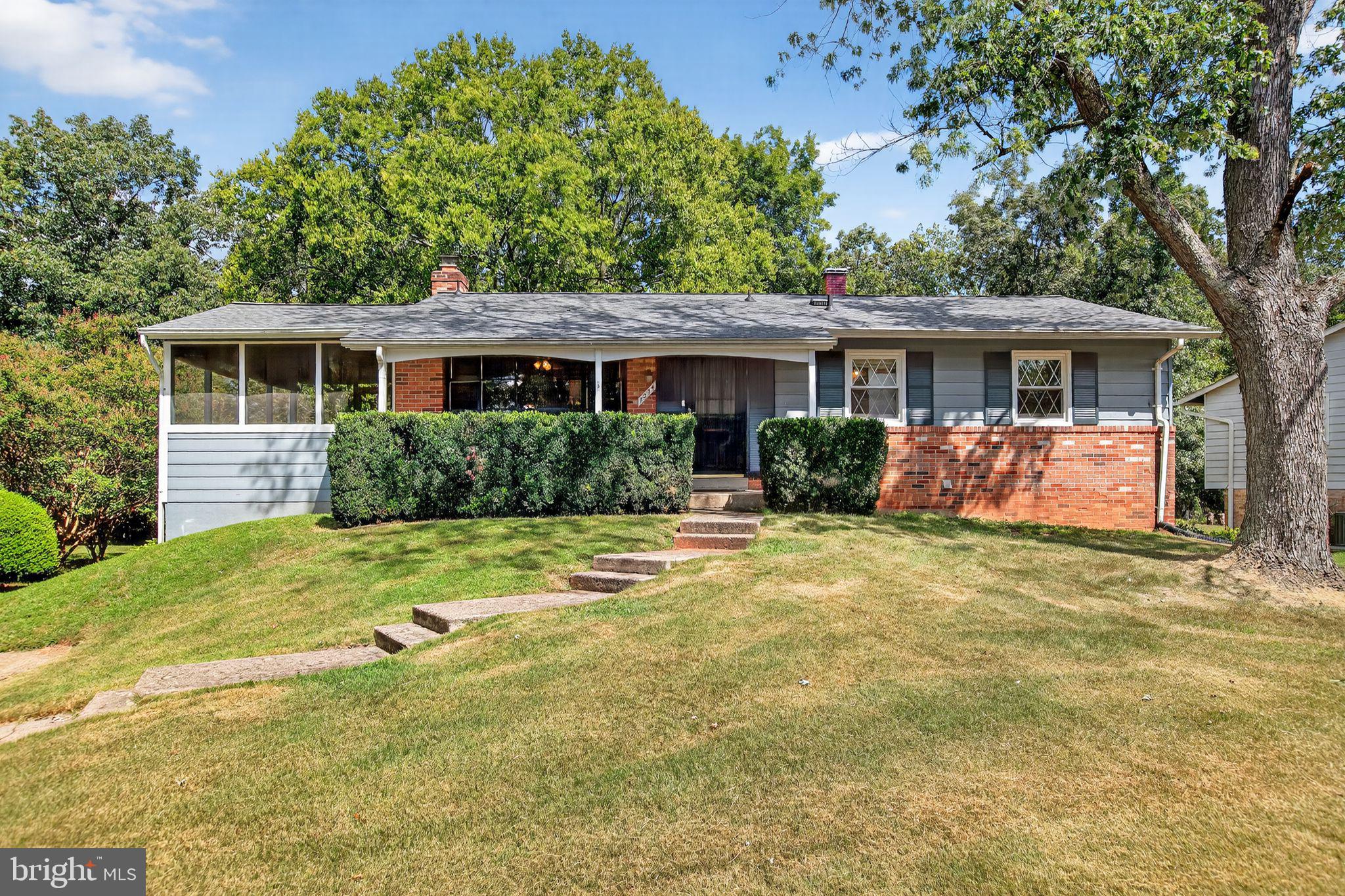 a front view of house with yard and trees around
