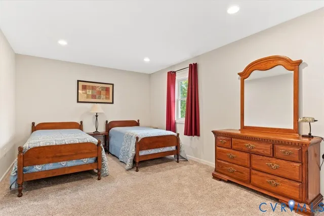 a bedroom with a bed and a dresser with mirror