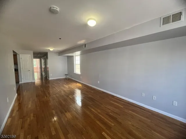 a view of an empty room and wooden floor