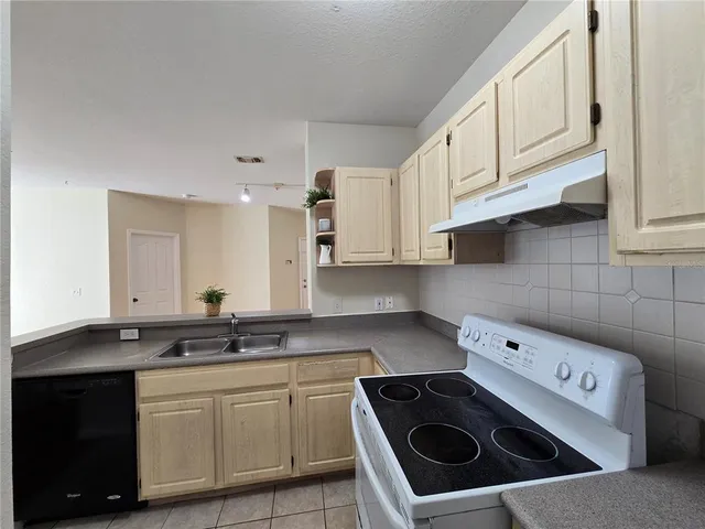 a kitchen with stainless steel appliances a sink a stove a microwave and cabinets
