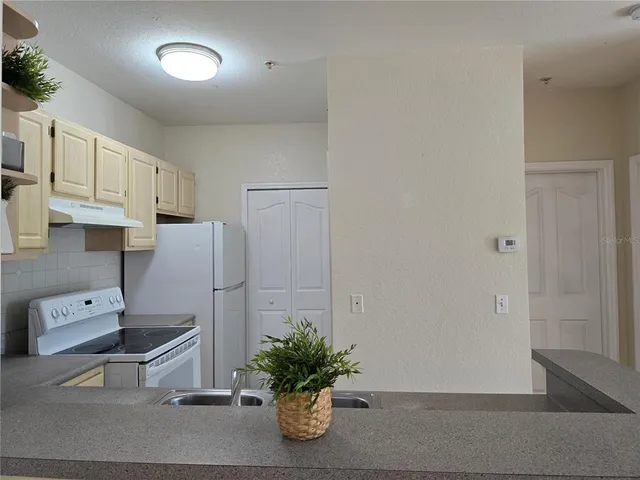 a kitchen with stainless steel appliances white cabinets and a refrigerator