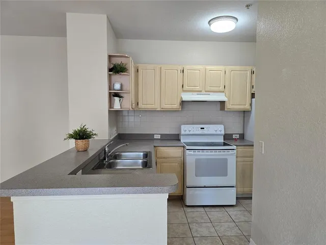a kitchen with a stove white cabinets and a sink