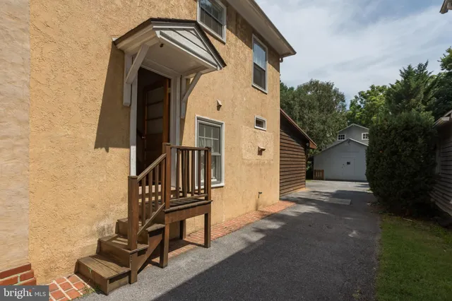 a view of a hallway with wooden floor and furniture