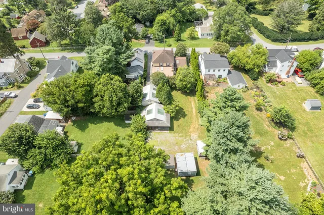 an aerial view of a house with a yard and large trees