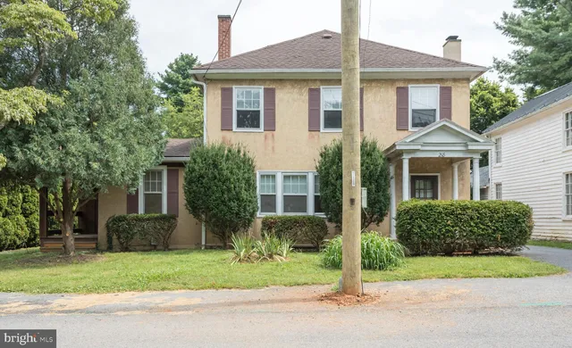 a front view of a house with a yard and trees