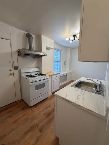 a kitchen with a stove a sink and a refrigerator