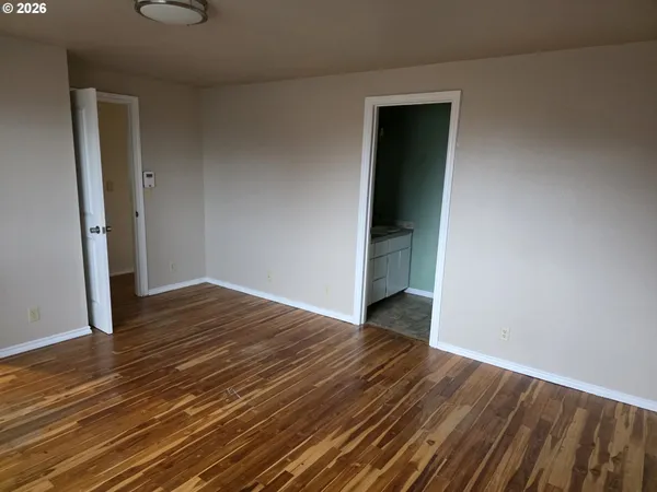 an empty room with wooden floor and closet