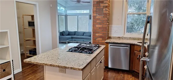a kitchen with a stove a sink a refrigerator and wooden floor