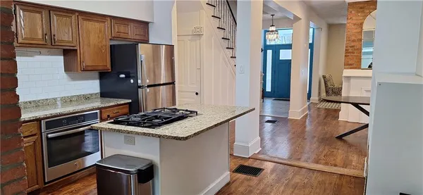 a kitchen with stainless steel appliances granite countertop a stove refrigerator and microwave