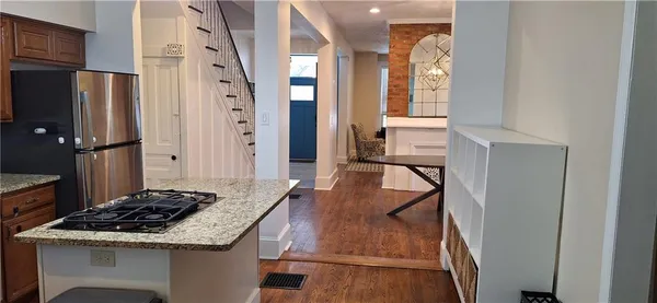 a kitchen with stainless steel appliances granite countertop a refrigerator and a stove