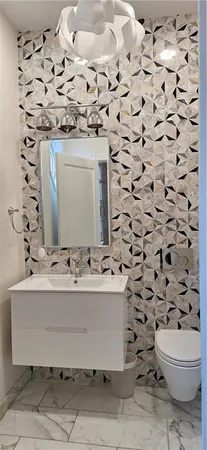 a bathroom with a sink toilet and mirror