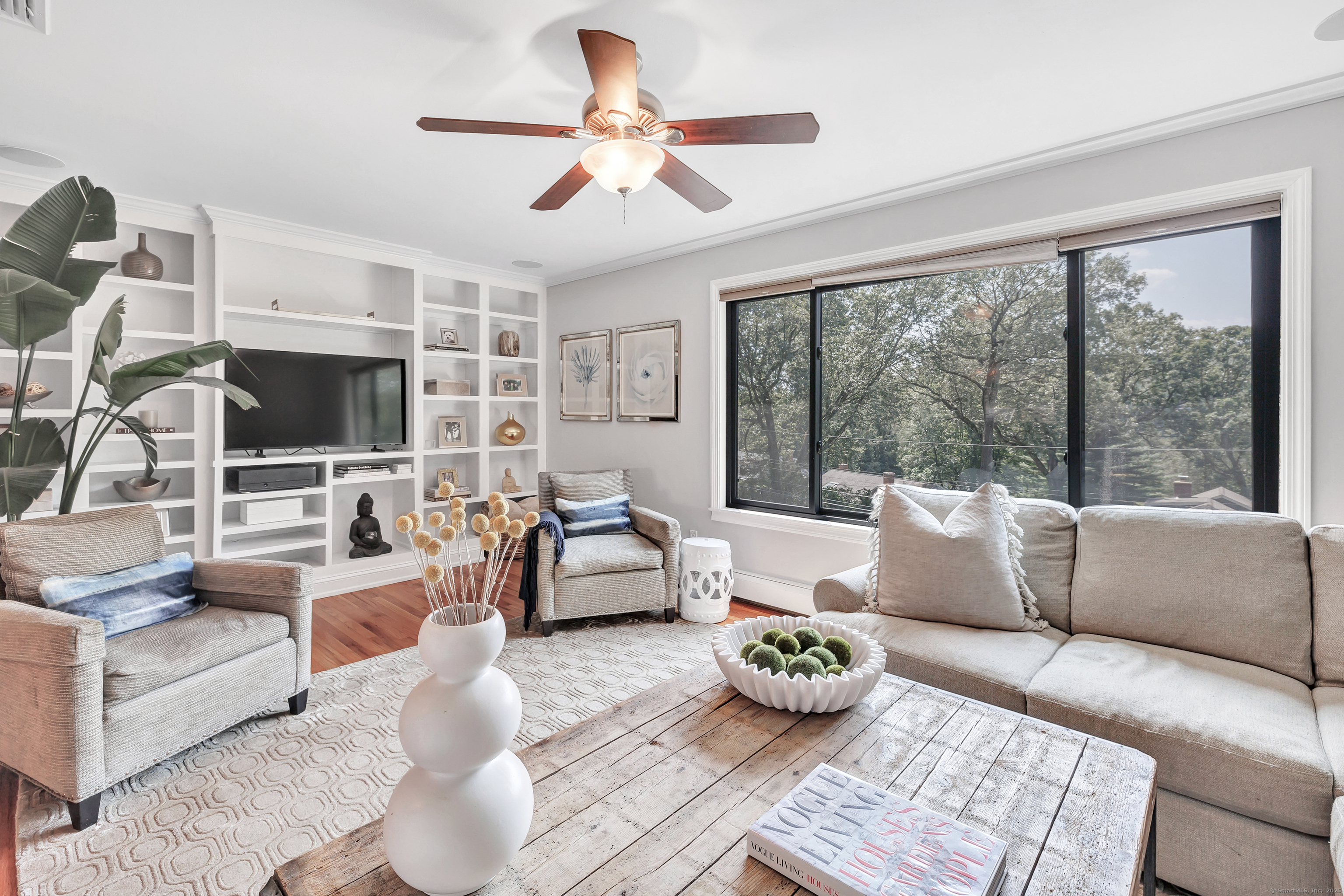 a living room with furniture a flat screen tv and a large window