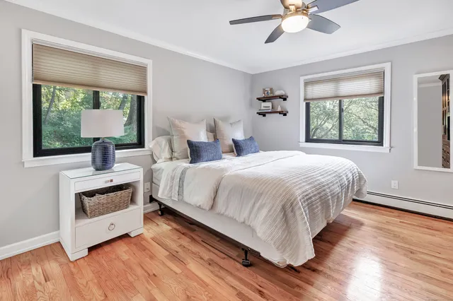 a bedroom with a bed and a chandelier fan