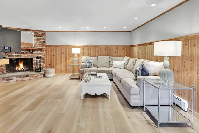 a living room with furniture a flat screen tv and a fireplace